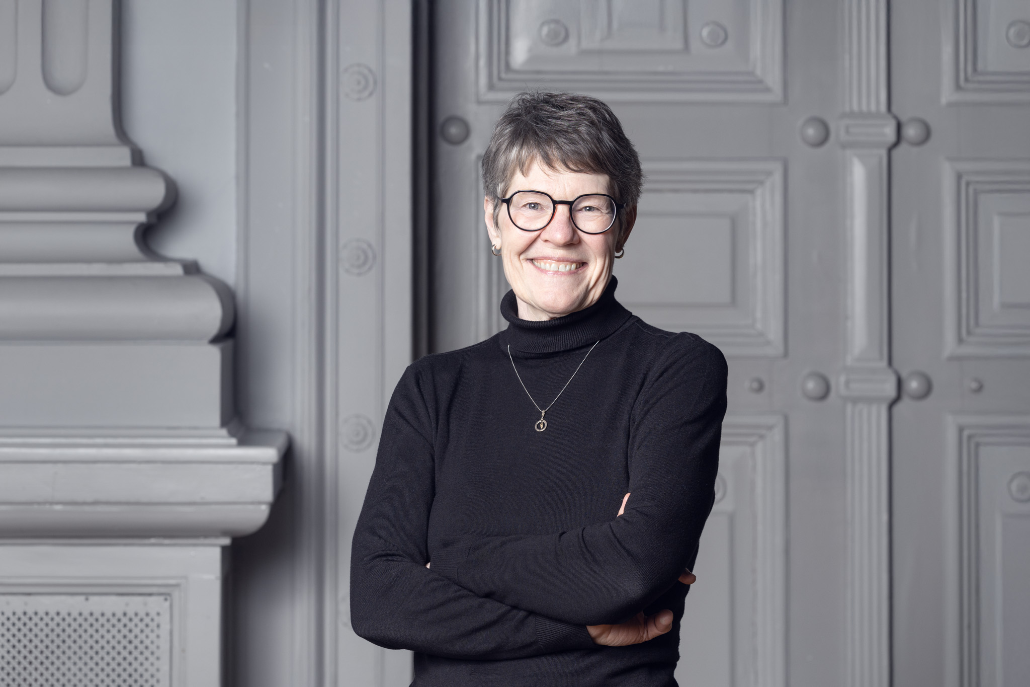 På bilden syns en äldre kvinna vid namn Katarina Rejman, sakkunnig inom utbildning vid Svenska folkskolans vänner. Hon har kortklippt grått hår, mörka tunna glasögon och är klädd i svart polotröja. Hon har ett smycke i silver kring halsen och står med händerna korslagda över bröstet. Hon ser rakt in i kameran och ler.